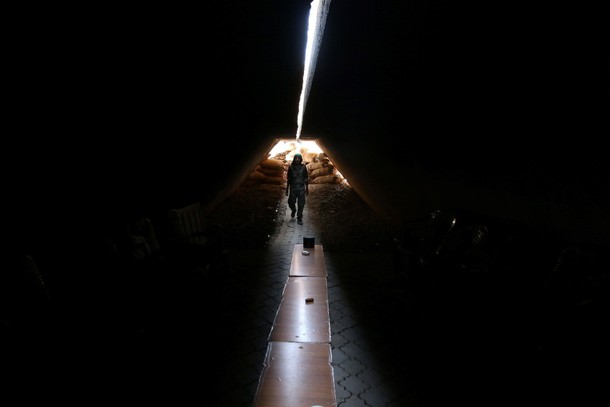 A fighter of the Syria Democratic Forces walks inside a shelter in northern province of Raqqa