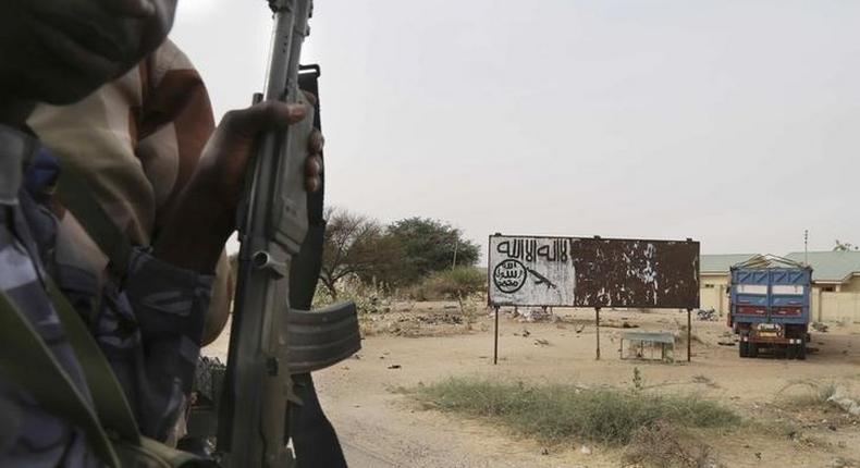 Chadian soldiers drive past a signpost painted by Boko Haram in the recently retaken town of Damasak, Nigeria, March 18, 2015. REUTERS/Emmanuel Braun