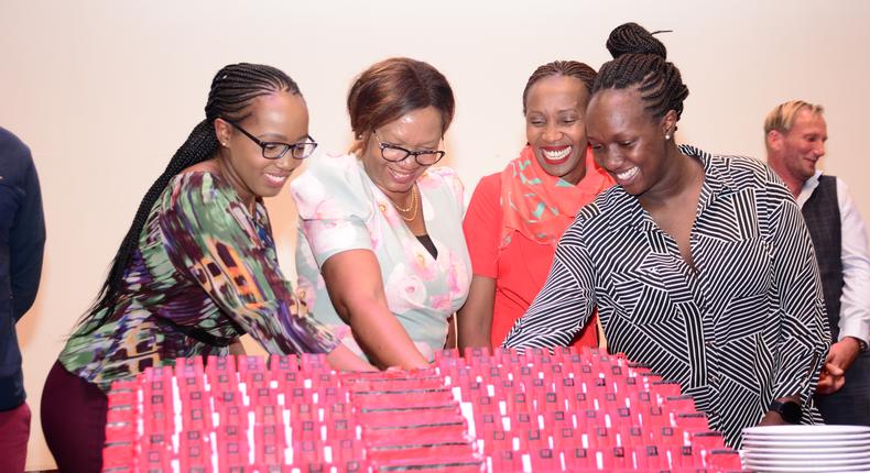 Rahab and the management team cut a cake to celebrate the opening of RMK Auditorium,