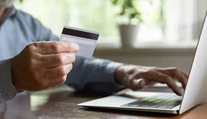 A stock image shows an older man making a payment online using his credit card.iStock/Getty Images