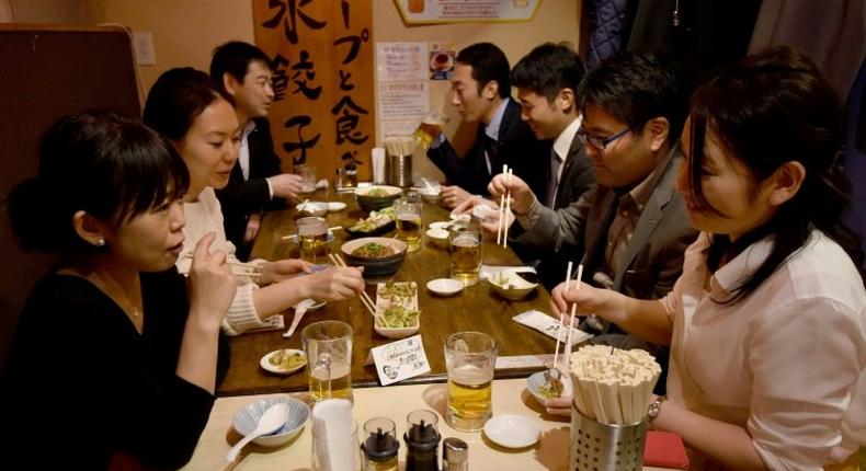 Suntory employees drink at a pub after finishing work at three o'clock in Tokyo, on February 24, 2017