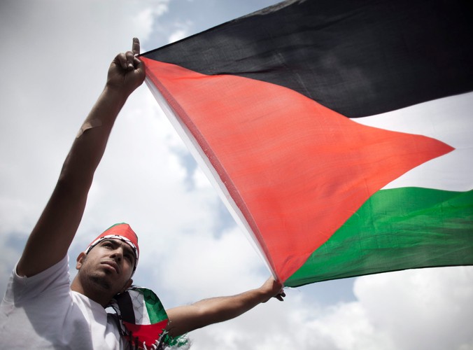 Mężczyzna z flagą palestyńską podczas starć w Ramallah