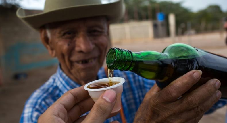 Venezuelan distiller Dolores Gimenez, 84, serves a cup of cocuy, a traditional liquor, at the Coari craft distillery in Bobare