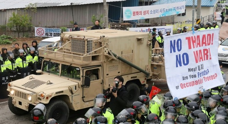 Protesters and police stand by as trailers carrying US THAAD missile defence equipment enter a deployment site in Seongju, on April 26, 2017