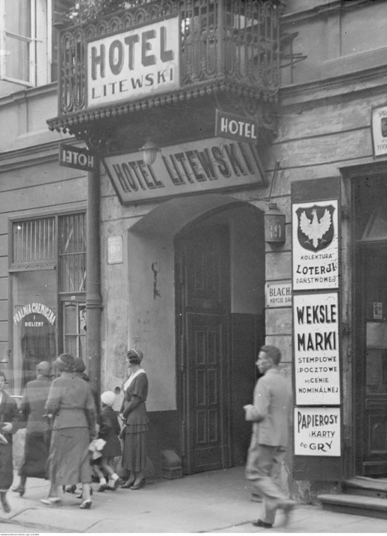 Fragment budynku z wejściem do hotelu przy ulicy Chmielnej 19. Widoczne szyldy reklamowe / 1932 rok