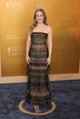 Kristen Bell egy Armani Privé ruhában tündökölt, amely tökéletesen ötvözte az eleganciát és a modern kifinomultságot. A pánt nélküli, földig érő ruhaköltemény finoman testhez simuló szabásával és réteges, áttetsző tüllbetéteivel különleges textúrát adott. A színésznő a megjelenését minimalista ékszerekkel tette teljessé, amelyek nem vonták el a figyelmet a ruha részleteiről. Haja lágy hullámokban omlott a vállára, sminkje pedig természetességet tükrözött. Az összhatás egyszerre volt romantikus és modern, tökéletes választás egy olyan eseményre, ahol a klasszikus glamour és a friss, kortárs elegancia találkozik.