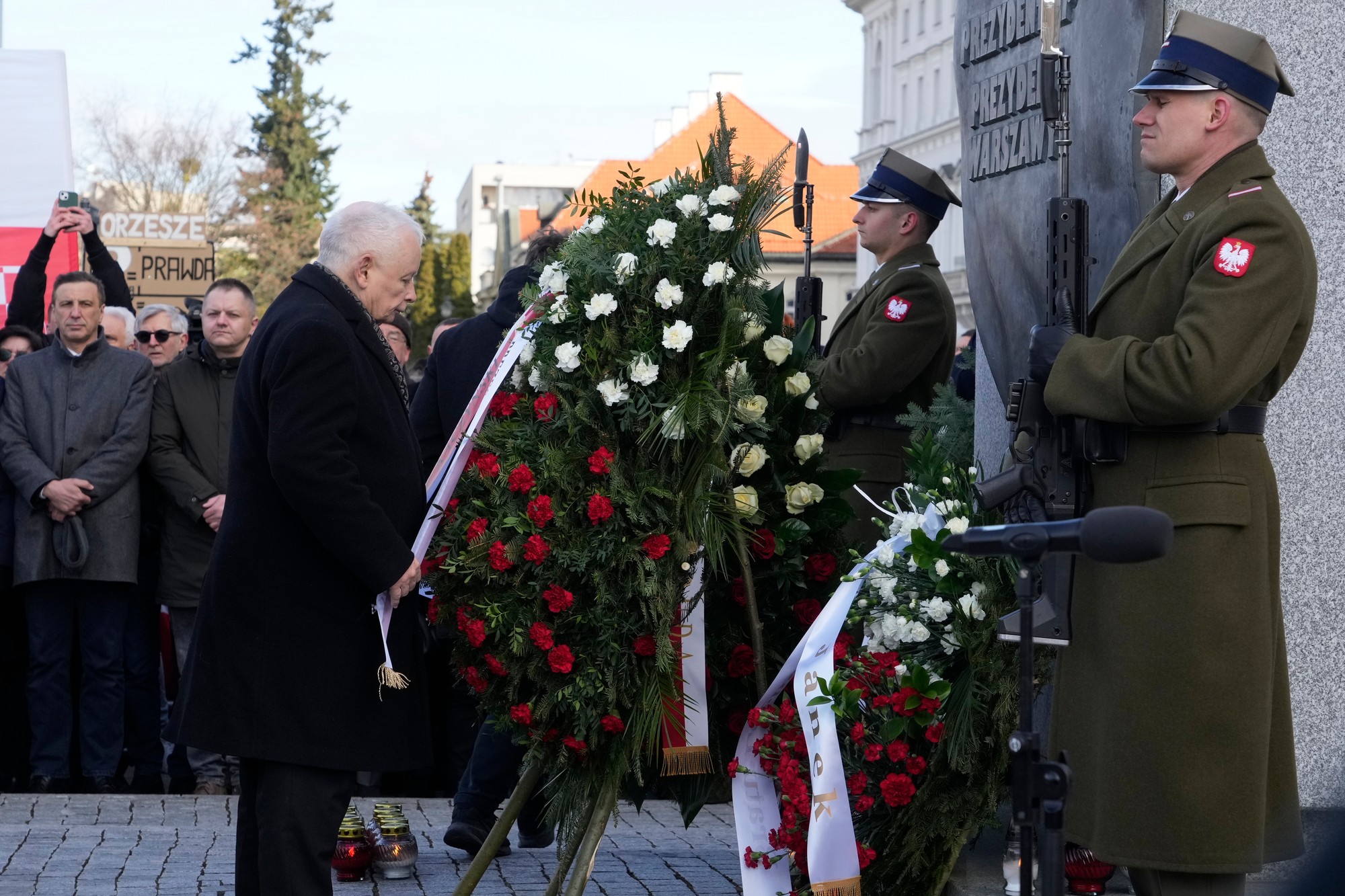 Predseda poľskej vládnej strany PiS Jaroslaw Kaczyňski (uprostred) vzdáva úctu svojmu bratovi a bývalému poľskému prezidentovi Lechovi Kaczyňskému pri príležitosti 15. výročia leteckého nešťastia.