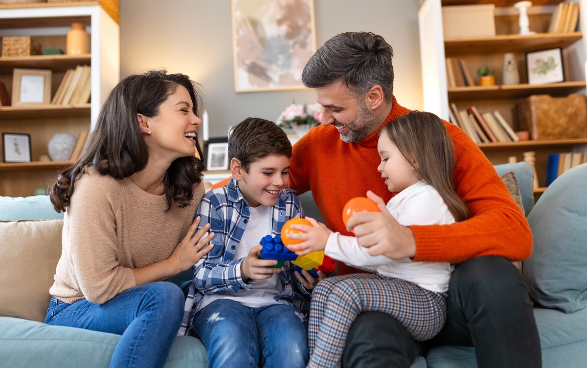 Kobieta i mężczyzna siedzą na kanapie z chłopcem i dziewczynką
