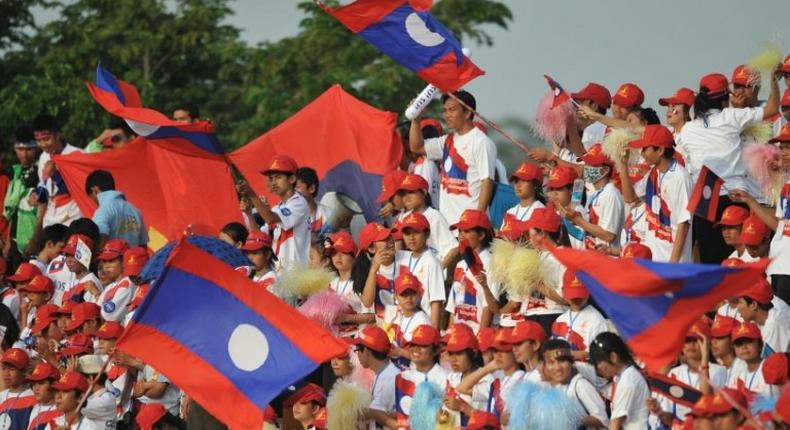 Laos supporters wave national flags during a football match in Vientiane
