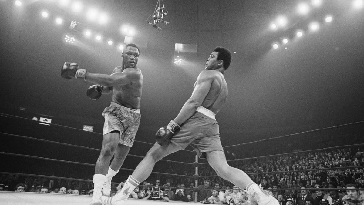 Muhammad Ali cofa się po ciosie Joe Fraziera podczas walki o tytuł mistrza wagi ciężkiej w Madison Square Garden w 1971 r. Po piętnastu rundach jednogłośną decyzją sędziów zwyciężył Frazier.