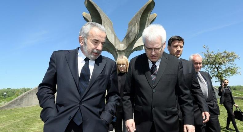 Coordinator of the Jewish communities in Croatia Ognjen Kraus (L) and Croatian rabbi of the Jewish community Luciano Mose Prelevic (R) walk in front of a memorial in the shape of a flower in Jasenovac on April 15, 2016