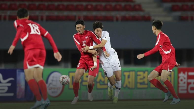 South Korea's Hwang Ui-jo and North Korea's Ri Yong Jik fight for the ball during the World Cup 2022 Qualifying match in Pyongyang