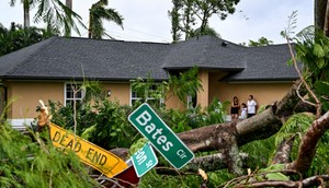 Oscar Garcia with his family outside his house after getting hit by a reported tornado in Fort Myers, Florida.CHANDAN KHANNA/AFP/Getty Images