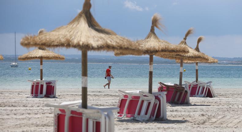 A tourist walks on Alcudia beach on June 18, 2020, in Alcudia, Mallorca, Spain.Clara Margais/Getty Images