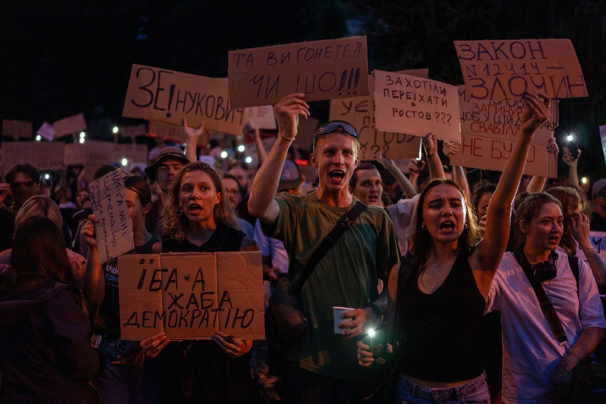 Demonštranti držia transparenty počas protestu proti zákonu obmedzujúcemu autonómiu protikorupčných úradov v Kyjeve.