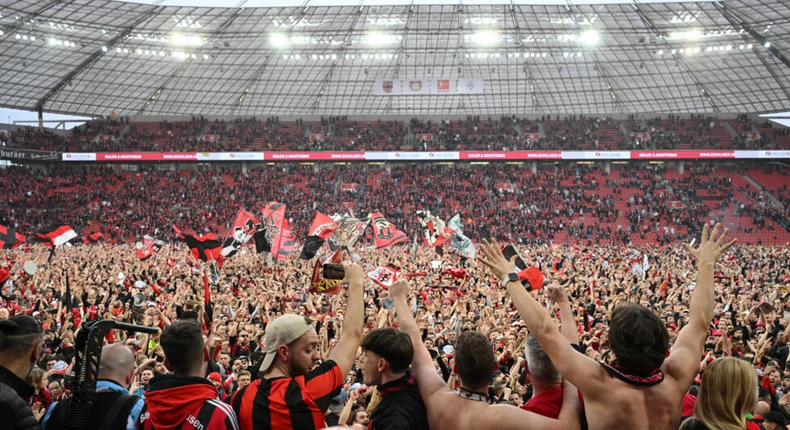 Les supporters du Bayer Leverkusen exultent sur la pelouse de la BayArena après le sacre de leur équipe en championnat d'Allemagne, le 14 avril 2024  AFP INA FASSBENDER