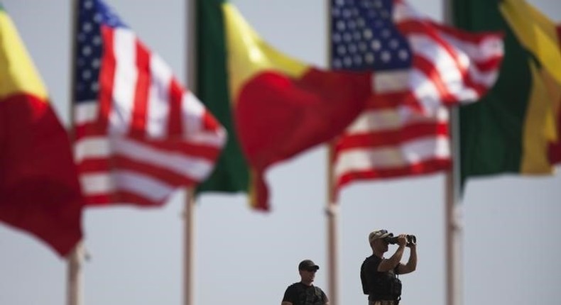 American security officers scan the airport from a rooftop below Senegalese and American flags before the departure of U.S. President Barack Obama in Dakar, Senegal, June 28, 2013. REUTERS/Joe Penney