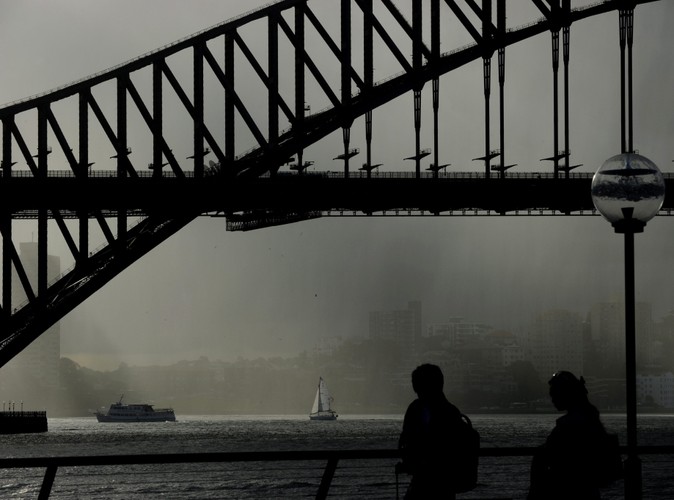Słońce próbuje się przebić przez deszcz w okolicach słynnego Mostu Portowego w Sydney w Australii