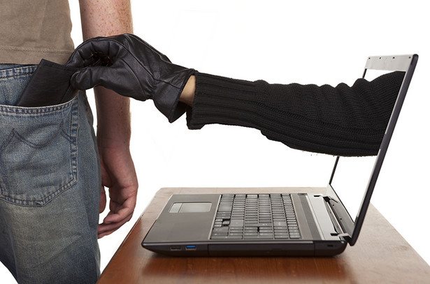 Internet theft - a gloved hand reaching through a laptop screen to steal a wallet from a man.