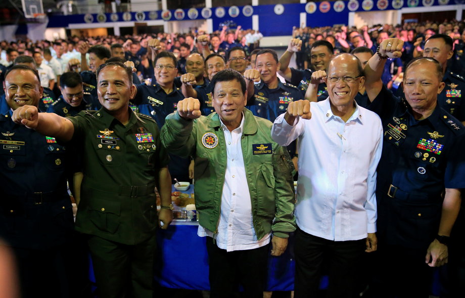 President Rodrigo Duterte, center, clenches a fist along with other Philippine Air Force (PAF) officials during the 250th Presidential Airlift Wing (PAW) anniversary at the Villamor air base in Pasay City, metro Manila, Philippines, September 13, 2016.