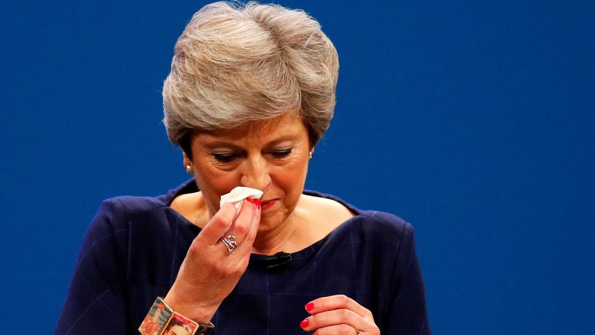Britain's Prime Minister Theresa May wipes her nose after she suffered a coughing fit whilst addressing the Conservative Party conference in Manchester