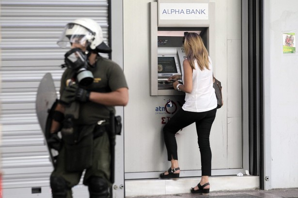 Kobieta wypłacająca pieniądze z bankomatu. Grecja, 2.07.2015