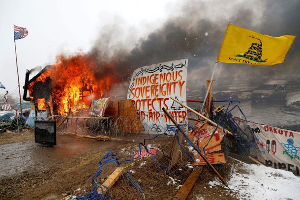 A structure burns after being set alight by protesters preparing to evacuate the main opposition cam