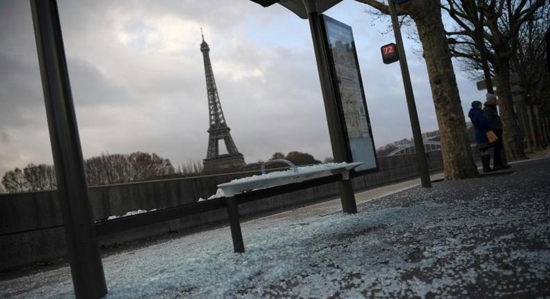 Cleaners swept up broken glass from smashed shop windows and bus stops across Paris on Sunday