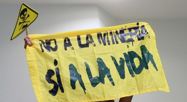 A woman holds a banner reading No to mining. Yes to life during a protest against mining at the Legislative Assembly in San Salvador on March 29, 2017