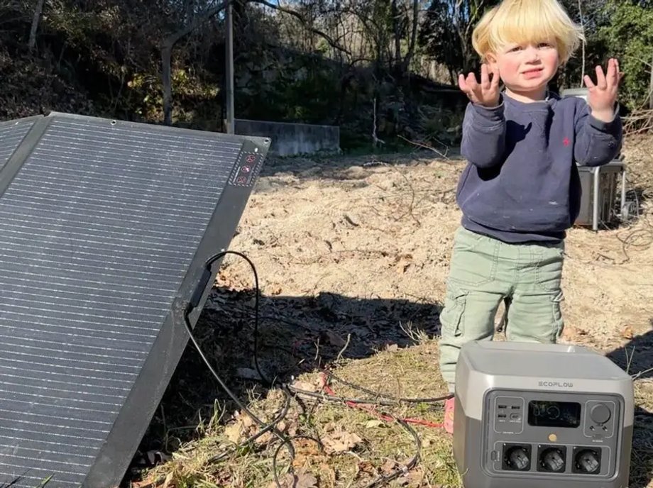 Jeden z synów pary, Crusoe, stoi obok instalacji solarnej.