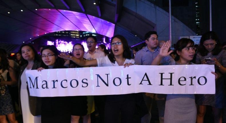 Protesters demonstrate in Manila following the burial of the late dictator Ferdinand Marcos in a secretive ceremony at the national heroes' cemetery