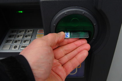 Latem Polacy rzadziej chodzą do bankomatów, ale wypłacają z nich więcej pieniędzy