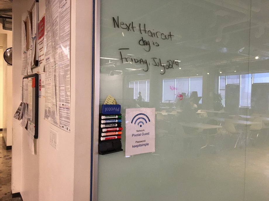 A sign advertises the next Pivotal haircut day, where employees get free haircuts at the office.