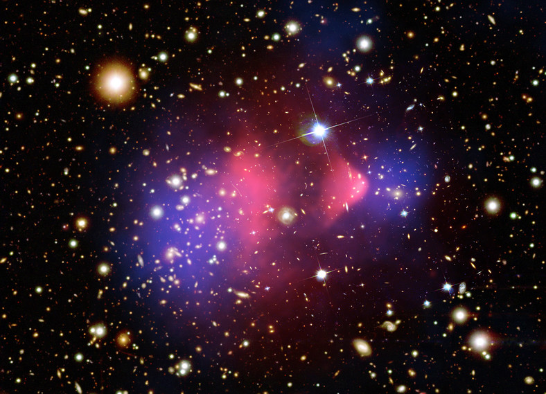 Gromada Pocisk (z ang. The Bullet Cluster) to jeden z naszych najlepszych dowodów na istnienie ciemnej materii. Tak naprawdę jest to efekt zderzenia dwóch gromad galaktyk. Skupiska ciemnej materii (fiolet) poruszają się szybciej niż "zwykłej" materii (róż), ponieważ oddziałują wyłącznie grawitacyjnie. Gdyby tak nie było, fiolet i róż powinny nachodzić na siebie.