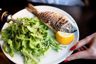 Grilled whole sea bream served with rocket salad and lemon