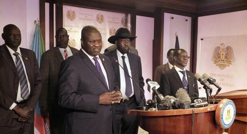 Riek Machar (L), flanked by South Sudan President Salva Kiir (C) and other government officials, addresses a news conference at the Presidential State House in Juba, South Sudan, July 8, 2016. 