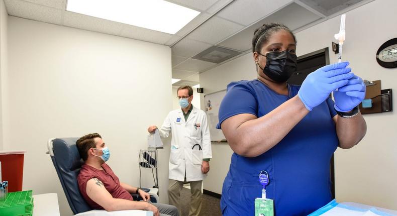 Chanei Henry, senior research coordinator of molecular virology and microbiology at Baylor College of Medicine, prepares a COVID-19 booster shot during a mix-and-match trial.
