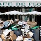 A waiter stands near a pile of rubbish bags in front of the Cafe de Flore in Paris during a strike of garbage collectors and sewer workers of the city of Paris to protest the labour reforms law proposal