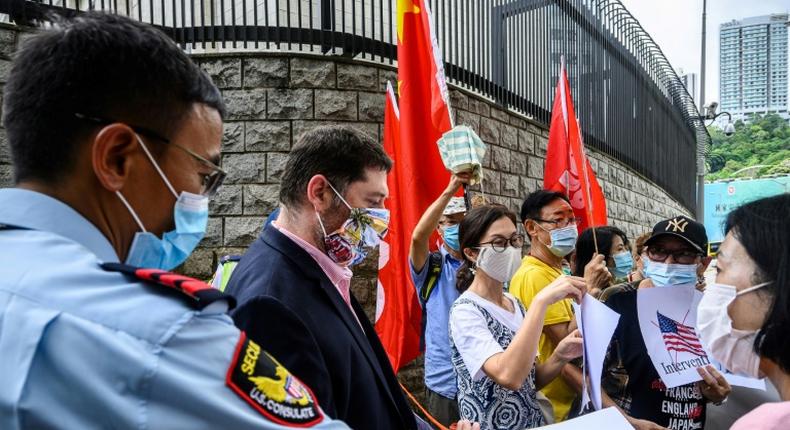 Pro-China activists holding placards and flags hand over a petition at the US consulate general in Hong Kong -- Washington has now imposed visa restrictions on Chinese officials over curbs on the city's autonomy