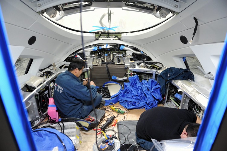 Dzięki połączeniu koncern China Railway tabor Corp (CRRC) będzie mógł poprawić efektywność w wykorzystaniu zasobów obu firm, dzięki czemu będzie możliwe obniżenie kosztów operacyjnych, co pozwoli na zwiększenie konkurencyjności i realizację strategii międzynarodowej.<br><b>Na zdjęciu: </b>Pracownik montażu w kabinie pociągu CRH-380B w auli China CNR Corporation, producenta lokomotyw i taboru na rynku chińskim <br><br> Fot. EPA / PETER Trebitsch DOSTAWCA: PAP / EPA.