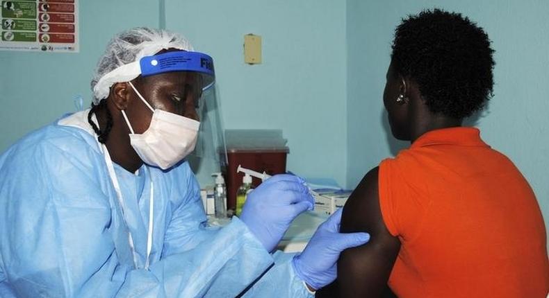 A health worker injects a woman with an Ebola vaccine during a trial in Monrovia, February 2, 2015. REUTERS/James Giahyue