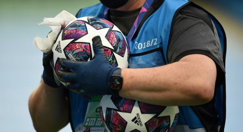 A member of the ground staff disinfects a ball before the Champions League last 16 match between Manchester City and Real Madrid at the Etihad Stadium in Manchester on August 7