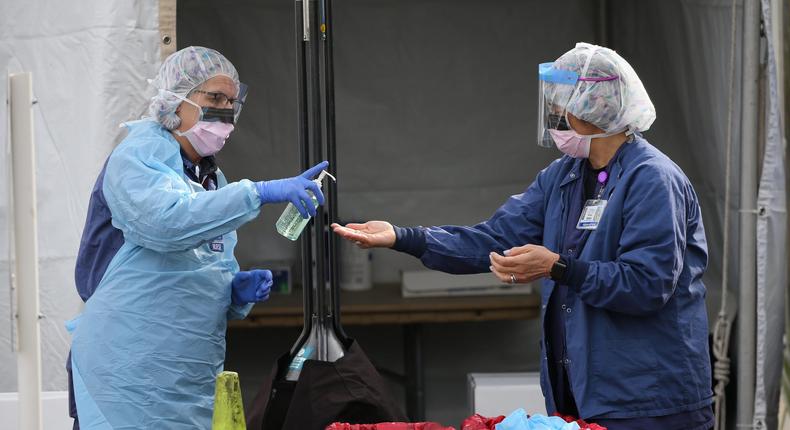 SEATTLE, WA - MARCH 17: Nurses clean their hands with disinfectant after a patient was screened for COVID-19 at an appointment-only, drive-up clinic set up by the University of Washington Medical Center Northwest Outpatient Medical Center on March 17, 2020 in Seattle, Washington. The clinic was set up to provide additional screening capacity, support personal protective equipment conservation efforts and help reduce the number of patients entering healthcare facilities for testing during the coronavirus outbreak. (Karen Ducey/Getty Images)