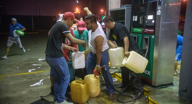 Residents pilfer gasoline and diesel from a gas station following protests against an increase in fuel prices, in Allende, southern Veracuz State, Mexico, late on January 3, 2017.