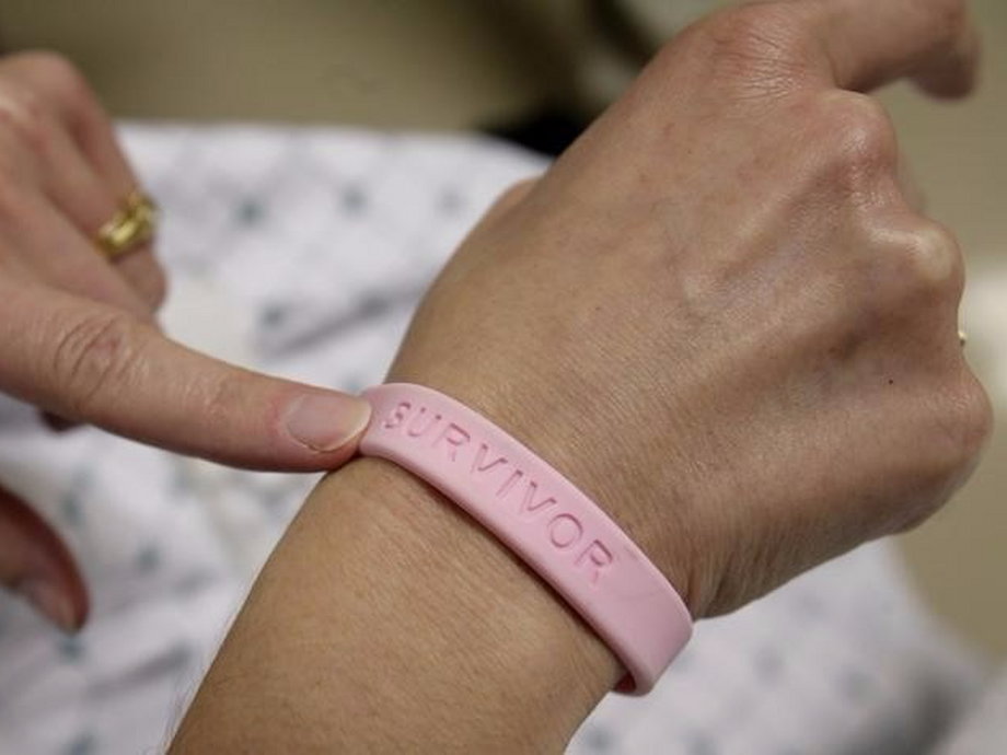 After three operations and four rounds of chemotherapy at Georgetown University Hospital, cancer patient Deborah Charles shows off her breast cancer survivor bracelet.