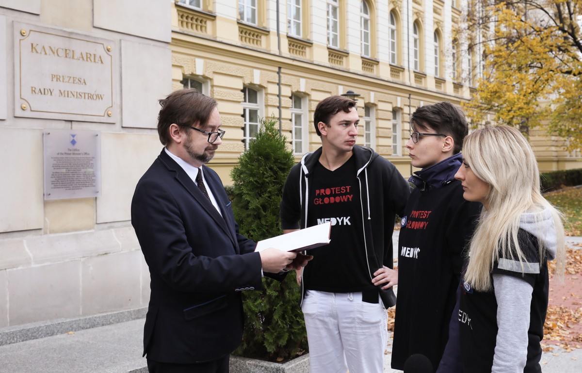 Zastępca szefa Kancelarii Prezesa Rady Ministrów Paweł Szrot (L) odebrał petycję od przedstawicieli rezydentów, którzy protestowali 14 bm. przed KPRM w Warszawie Ponad 20 lekarzy rezydentów od 2 bm. prowadzi głodówkę w Dziecięcym Szpitalu Klinicznym w Warszawie. Domagają się wzrostu finansowania ochrony zdrowia, zmniejszenia biurokracji, skrócenia kolejek, zwiększenia liczby pracowników medycznych, poprawy warunków pracy i podwyższenia wynagrodzeń.