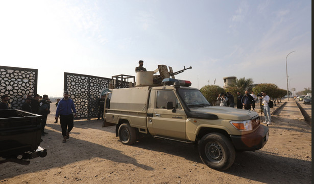 Członkowie irackich szyickich Sił Mobilizacji Ludowej (PMF) w pobliżu bramy po zgłoszonym ataku drona na kwaterę główną sił bezpieczeństwa w Bagdadzie, 4 stycznia