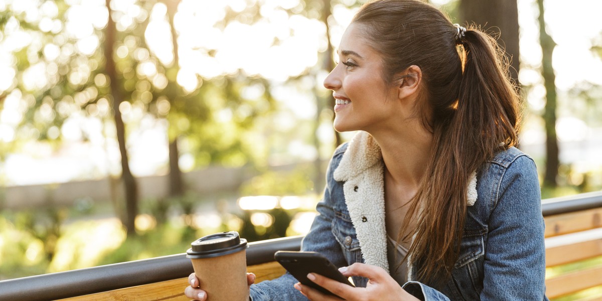 Smiling young woman wearing jacket and sunglasses