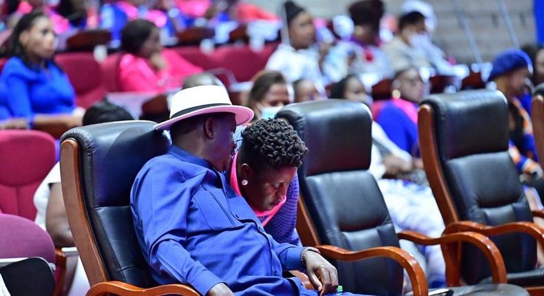 Former Kenyan Prime Minister Raila Odinga having a chat with his youngest daughter Winnie Odinga during a church service in December 2021