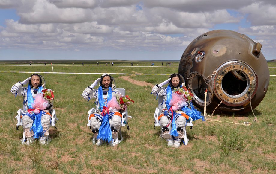 Astronauts Zhang Xiaoguang, Nie Haisheng, and Wang Yaping salute after returning to Earth in China's Shenzhou 10 spacecraft on June 26, 2013, after successfully docking with a crewed space laboratory.